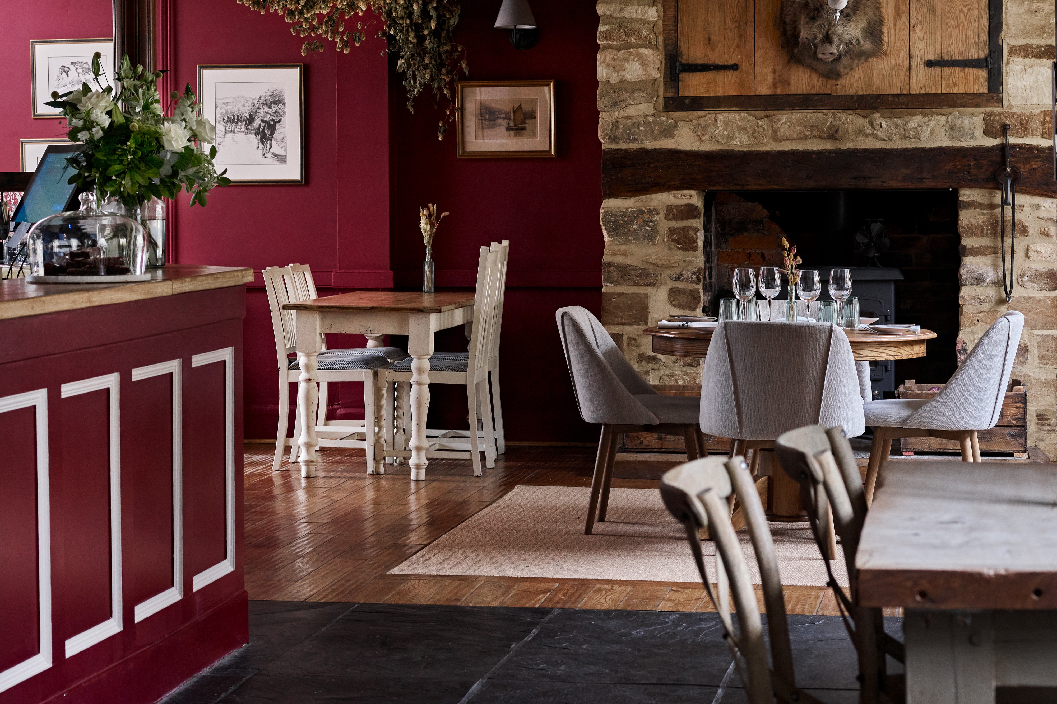 Crimson-walled dining room with a stone fireplace at the Barrington Boar, Barrington